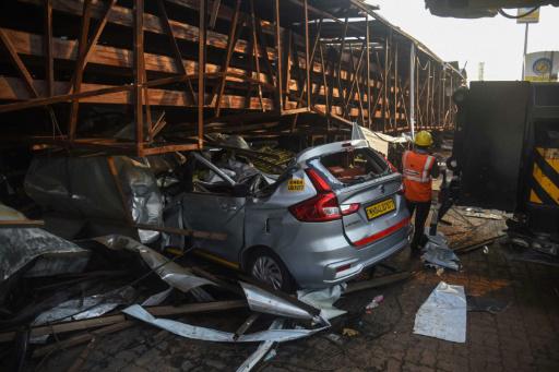 Un vehículo aplastado por la valla publicitaria caída en una gasolinera de Bombay tras una tormenta, en una imagen del 14 de mayo de 2024