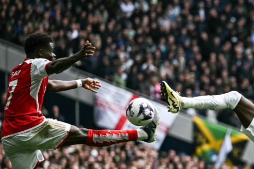 El volante inglés del Arsenal Bukayo Saka (izquierda) controla el balón durante el partido de la Premier League inglesa entre Tottenham Hotspur y Arsenal en el Tottenham Hotspur Stadium de Londres, el 28 de abril de 2024
