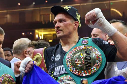 El ucraniano Oleksandr Usyk (C) celebra su victoria sobre el británico Tyson Fury en Riad, para convertirse en el campeón mundial indiscutido de los pesos pesados el 19 de mayo de 2024