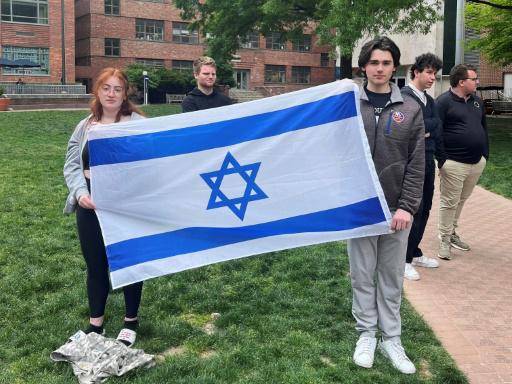 La estudiante de filosofía Skyler Sieradzky (I) sostiene una bandera de Israel mientras manifestantes propalestina hacen una sentada en el campus urbano de la Universidad George Washington, en Washington