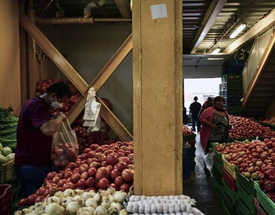 AFP | La gente trabaja en Merca Panamá, el principal mercado de frutas y verduras de la ciudad de Panamá. Por un lado, algunos separan los mejores productos y otros los empaquetan.
