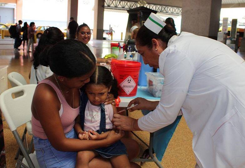Una enfermera aplica una vacuna a una niña.