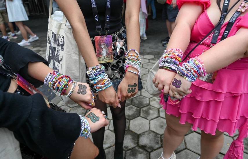 Los seguidores de la cantante estadounidense Taylor Swift exhiben pulseras de amistad.