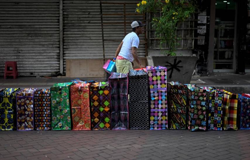 A man sells plastic bags in the street in Panama City on May 6, 2024. - Right-wing lawyer Jose Raul Mulino won Sunday’s presidential election in Panama and promised to take measures “without fear” to recover the economy and end “political persecution,” of which his mentor, former President Ricardo Martinelli, claims to be a victim. (Photo by JOHAN ORDONEZ / AFP)