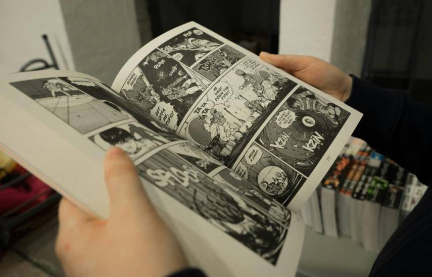 Unsplash | Un lector abre una obra de ficción con ilustraciones conocidas como manga, cuya característica son los ojos grandes y brillantes de los personajes.