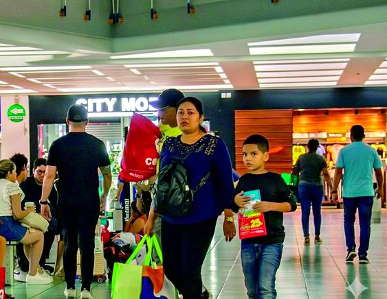 IMAGEN GENERADA CON IA | Personas caminan en un centro comercial.