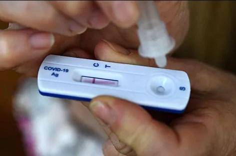 AFP | Una prueba casera para detectar el coronavirus es sostenida por una persona.