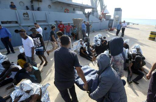 Unos migrantes africanos rescatados frente a la costa de Zuwara, en Libia, permanecen en un muelle de la base naval de Trípoli el 18 de junio de 2018