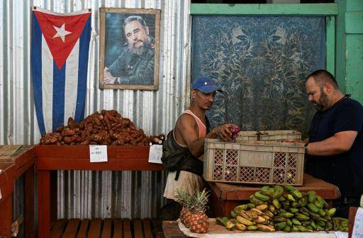 Un vendedor organiza sus productos en su puesto de La Habana, decorado con un retrato del fallecido presidente cubano Fidel Castro, el 13 de marzo de 2026