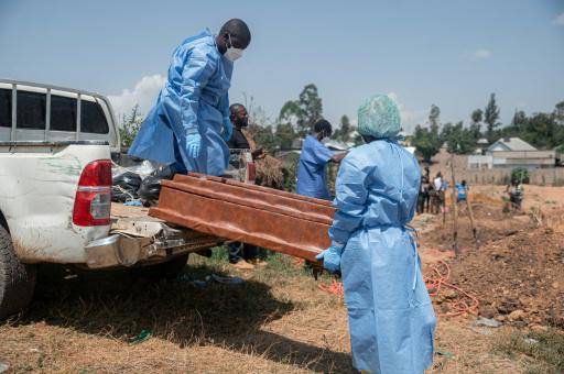 Equipos de la Federación Internacional de Sociedades de la Cruz Roja y de la Media Luna Roja descargan en el cementerio de Mbiyo el ataúd de un huérfano que murió de ébola en un orfanato de Bunia, el 19 de junio de 2026 al noreste de la República Democrática del Congo, cerca de la frontera con Uganda