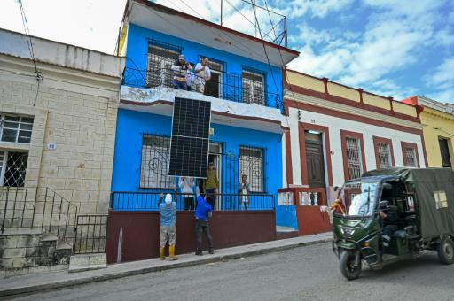 Unos instaladores colocan unos paneles fotovoltaicos en el tejado de un comedor gestionado por la iglesia católica en el barrio de Guanabacoa, en La Habana, el 4 de febrero de 2026