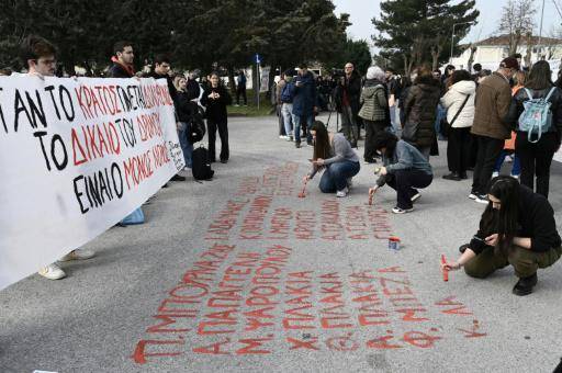 Unas jóvenes escriben los nombres de las 57 víctimas del accidente de tren de Tempi el 23 de marzo de 2026 en el campus universitario de Larissa, en Grecia