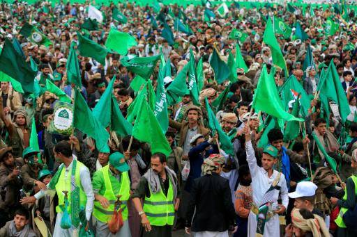 La multitud corea consignas y enarbola banderas mientras sigue un discurso del líder hutí Abdul Malik al Huthi en una pantalla grande, el 25 de agosto de 2026 en Saná, la capital de Yemen