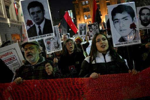 Unos participantes en una vigilia convocada en Santiago el 30 de agosto de 2024, Día Internacional de las Víctimas de Desapariciones Forzadas, exhiben retratos de detenidos desaparecidos durante la dictadura de Augusto Pinochet (1973-1990)