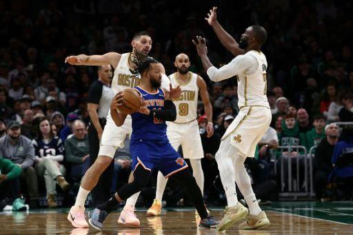 El astro Jalen Brunson (C), de New York Knicks, es doblemente marcado por Jaylen Brown (D) y Nikola Vucevic (I) de los Boston Celtics, durante el partido de la NBA jugado en el TD Garden, en Boston, el 8 de febrero de 2026