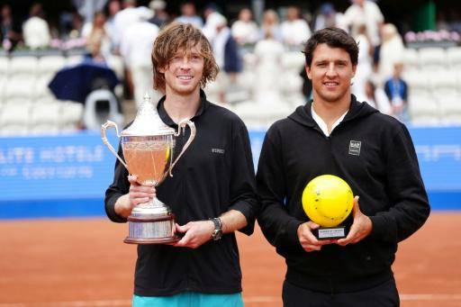 El ganador del torneo de Bastad, en Suecia, el ruso Andrey Rublev (izq.), posa con su trofeo junto al subcampeón, el italiano Luciano Darderi, el 19 de julio de 2026