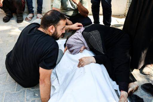 Una mujer palestina llora sobre el cuerpo, envuelto en un sudario, de una de las víctimas de un ataque aéreo israelí contra un vehículo, mientras los cuerpos son trasladados desde el hospital Al Shifa para su entierro, el 31 de agosto de 2026 en la ciudad de Gaza