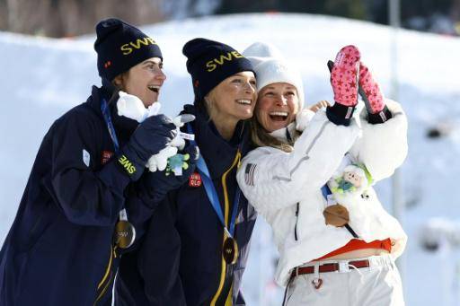 De izquierda a derecha, Ebba Andersson (plata), Frida Karlsson (oro) y Jessie Diggins (bronce) se toman un selfi en el podio de los 15 km individual libre del esquí de fondo de los Juegos Olímpicos de Invierno de Milán-Cortina. En Tesero (norte de Italia), el 12 de febrero de 2026