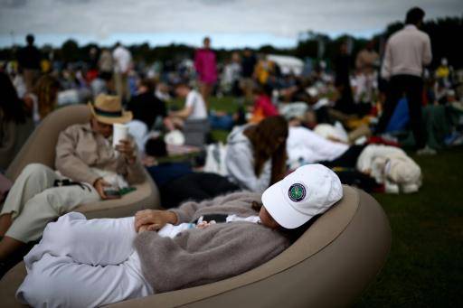 Una persona reposa en un sillón mientras guarda cola para entrar en el All England Lawn Tennis and Croquet Club de Wimbledon, en el suroeste de Londres, el 29 de junio de 2026