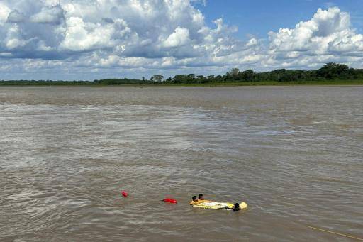 Una imagen divulgada por la Policía Nacional de Perú muestra a un equipo de rescate cerca de los restos de un barco afectado por el deslizamiento de tierra en el puerto fluvial de Iparia, en el departamento de Ucayali, el 1 de diciembre de 2025 en el centro de Perú