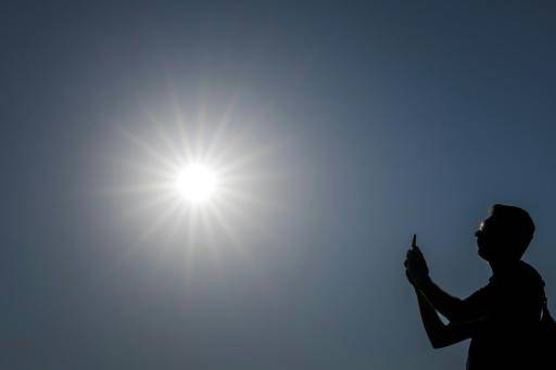 Una persona toma una fotografía bajo el sol en un caluroso 12 de agosto de 2025 en Ginebra