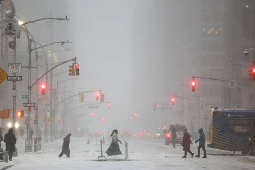 Varias personas cruzan la Sexta Avenida bajo una nevada en el distrito de Manhattan, el 25 de enero de 2026 en Nueva York
