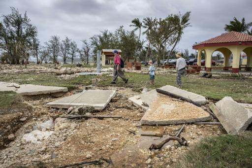 Varias personas pasan junto a una pasarela de un parque de Guam dañada por el paso del supertifón Bavi, el 7 de julio de 2026 en la isla estadounidense
