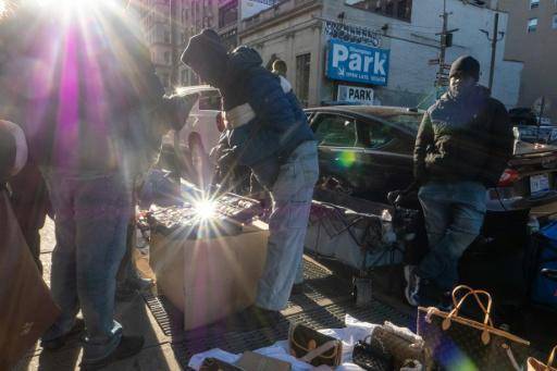 Unos vendedores callejeros, algunos llegados recientemente de países de África Occidental, muestran bolsos, relojes y bisutería el 1 de diciembre de 2025 en Canal Street, en Nueva York