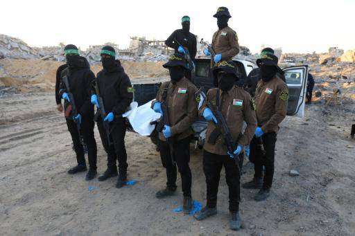 Militantes de los grupos Hamás y Yihad Islámica trasladan en una bolsa blanca los restos mortales de un supuesto rehén israelí, el 3 de diciembre de 2025 en la ciudad de Beit Lahia, al norte de la Franja de Gaza