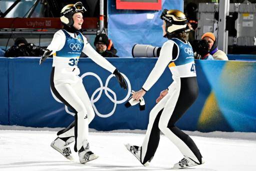 La noruega Anna Odine Stroem (derecha) celebra el oro en saltos de esquí gran trampolín, en Predazzo, el 15 de febrero de 2026, en los Juegos de Milán-Cortina