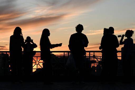 Varias personas contemplan el atardecer el 23 de junio de 2026 desde un punto de observación en Moscú
