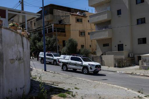 Dos vehículos de la policía israelí bloquean una calle de la ciudad árabe de Tayibe con mntivo de los tiroteos registrados en varios lugares del centro de Israel, el 7 de junio de 2026