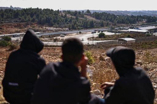 Unos jóvenes palestinos observan a fuerzas israelíes tomando posiciones en la prisión militar de Ofer, lozalizada entre Ramala y Beitunia, en Cisjordania ocupada, el 13 de octubre de 2025