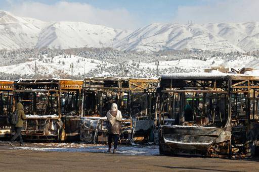 Esta fotografía de archivo, tomada durante una visita guiada para medios extranjeros, muestra unos buses estacionados que fueron incendiados en una cochera durante las protestas en Teherán, el 21 de enero de 2026