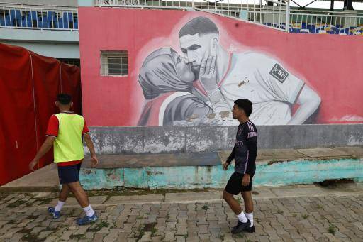 Jóvenes caminan junto a un mural que representa al futbolista internacional marroquí Achraf Hakimi en un estadio que lleva su nombre en Alcazarquivir en el norte de Marruecos, el 8 de enero de 2026