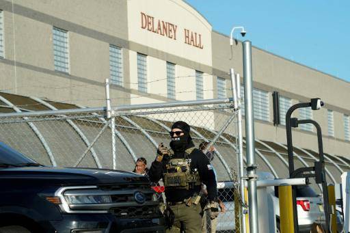 Unos agentes del Servicio de Inmigración y Control de Aduanas (ICE) de Estados Unidos vigilan a unos manifestantes fuera del centro de detención Delaney Hall, en Newark, Nueva Jersey, el 7 de mayo de 2025