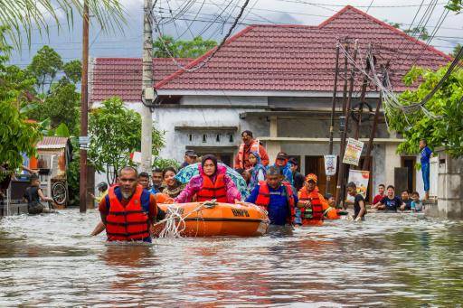 Un equipo de rescate evacua en un bote hinchable a mujeres y niños en una zona residencial de Padang, al oeste de Sumatra, el 25 de noviembre de 2025 en la isla indonesia