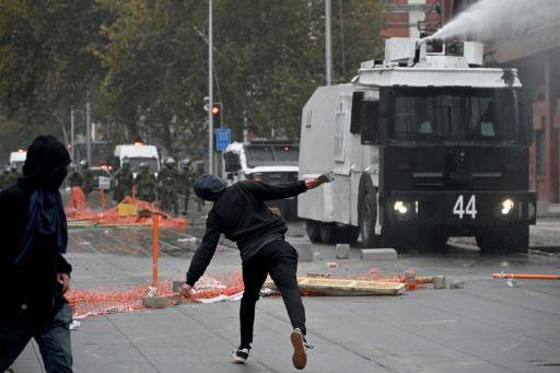 AFP | La policía antidisturbios lanza agua a los manifestantes durante una marcha en Santiago por el Día Internacional del Trabajo, el 1 de mayo de 2026.