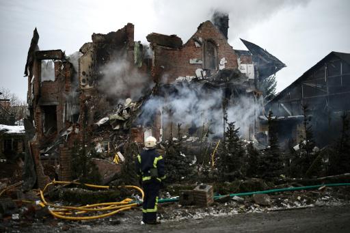 Un rescatista ucrananio frente a una casa fuertemente dañada por un bombardeo en la región de Kiev el 22 de febrero 2026, en el marco de la invasión rusa de Ucrania