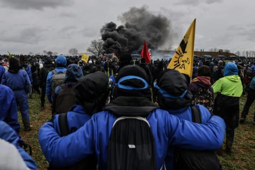 Unos manifestantes observan cómo arde un vehículo de los gendarmes durante la protesta contra el embalse agrícola en Sainte-Soline, Francia, el 25 de marzo de 2023