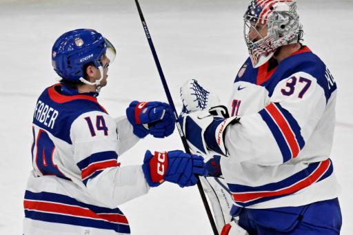 Los jugadores de la selección de Estados Unidos de hockey sobre hielo Brock Faber (14) y Connor Hellebuyck celebran el triunfo ante Alemania, el 15 de febrero de 2026 en Milán