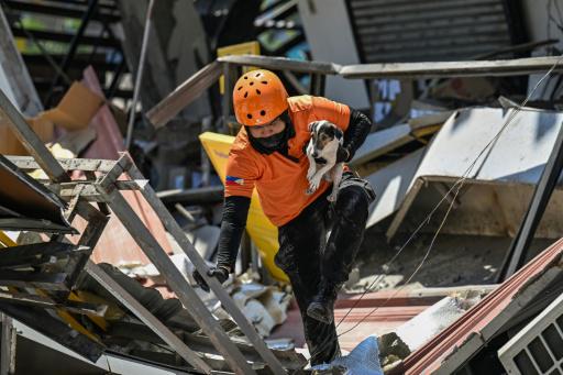 Un rescatista lleva a un perro de búsqueda durante las operaciones para localizar sobrevivientes entre los restos de un edificio derrumbado, el 9 de junio de 2026 en General Santos, Filipinas