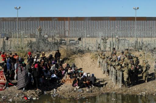 Antidisturbios de la Guardia Nacional de Texas impiden el paso a unos migrantes venezolanos en la orilla del río Grande, en la frontera de EEUU con México, una imagen captada el 22 de marzo de 2024 desde la mexicana Ciudad Juárez