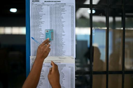 Unas personas comprueban el listado del censo electoral para saber en qué mesa votar en las elecciones presidenciales y legislativas de Perú, el 13 de abril de 2026 en una escuela de Lima