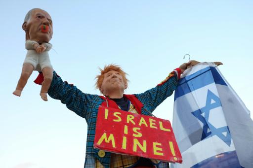 Un activista israelí de izquierda, disfrazado con una máscara que representa al presidente estadounidense Donald Trump, sostiene un muñeco que representa al primer ministro israelí Benjamin Netanyahu durante una manifestación contra el gobierno y la guerra en Oriente Medio