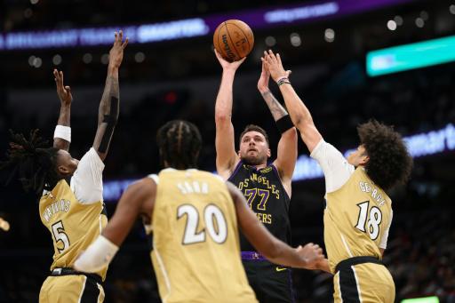 El esloveno Luka Doncic (77) tira al aro ante la marca de tres jugadores de los Washington Wizards el 30 de enero de 2026 en el Capital One Arena, en Washington, en la victoria de Los Angeles Lakers en partido de la NBA