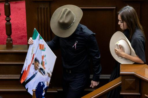 Grecia Quiroz, viuda del asesinado alcalde de Uruapan, Carlos Manzo, baja del estrado con el representante estatal Carlos Tafolla tras jurar como sucesora de su marido el 5 de noviembre de 2025 en el Congreso de Michoacán, en Morelia, México