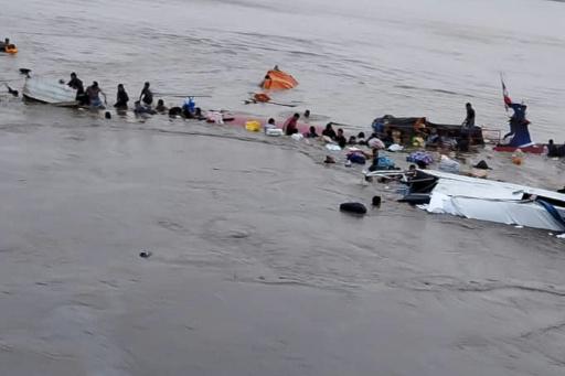 Una imagen divulgada por el Centro de Operaciones de Emergencia Regional (COER) muestra a varias personas junto a los restos de un barco afectado por el deslizamiento de tierra en el puerto fluvial de Iparia, en el departamento de Ucayali, el 1 de diciembre de 2025 en el centro de Perú