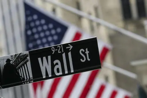 La bandera estadounidense ondea detrás de un letrero de Wall Street, cerca de la Bolsa de Nueva York (NYSE) en la ciudad de Nueva York, el 22 de abril de 2026.