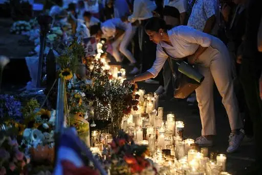 Una mujer enciende una vela para honrar a las víctimas del derrumbe de la discoteca Jet Set, el 12 de abril de 2025 en Santo Domingo